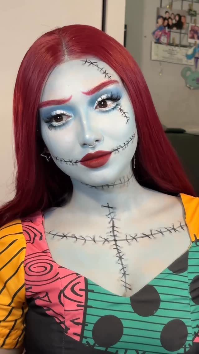 Person in Sally costume with blue skin, red hair, and patchwork dress.