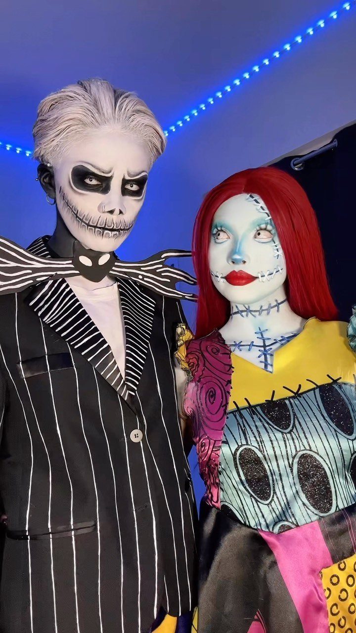 Jack and Sally cosplayers with detailed face paint and character costumes posing together.