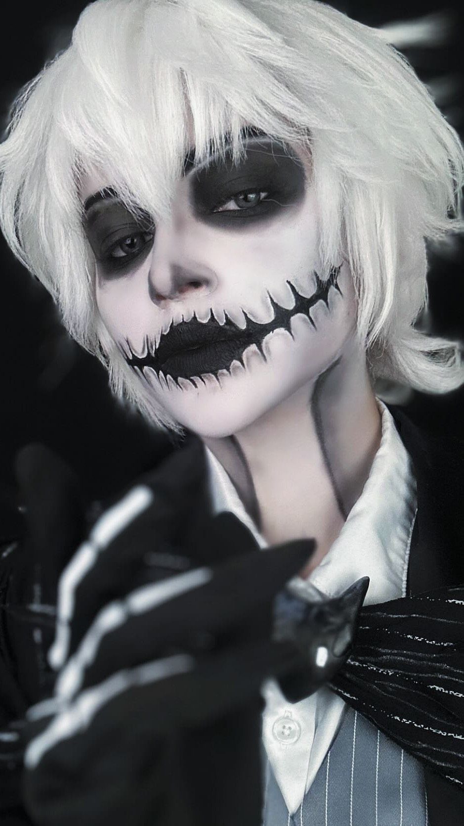 Person in Jack Skellington costume with white hair and skeletal face makeup.