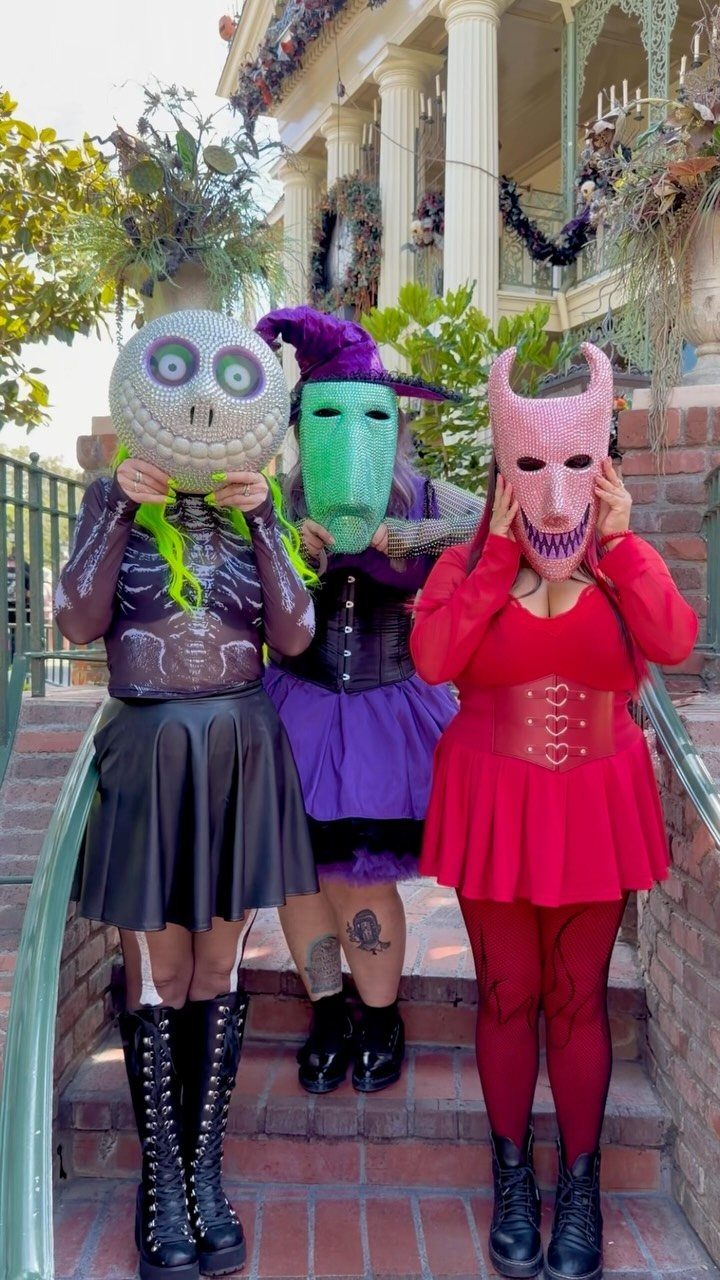Three people in Jack Skellington, Sally, and Oogie Boogie costumes posing on stairs.