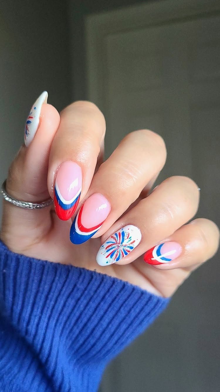 Patriotic nails with red and blue French tips and firework starburst designs.