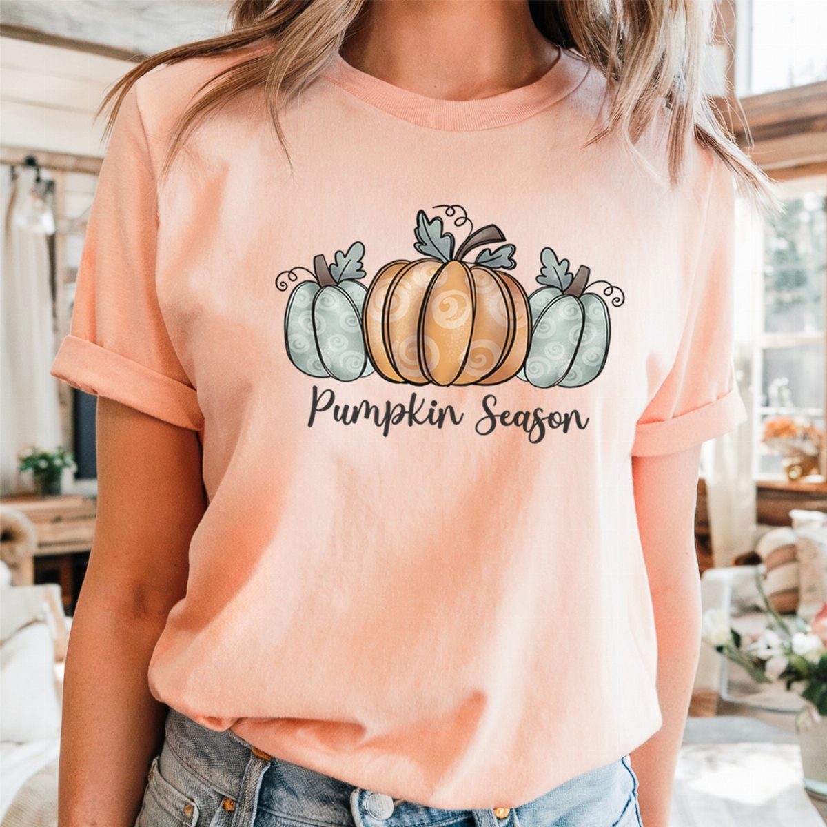 Peach t-shirt with pumpkin graphic and Pumpkin Season text paired with blue jeans