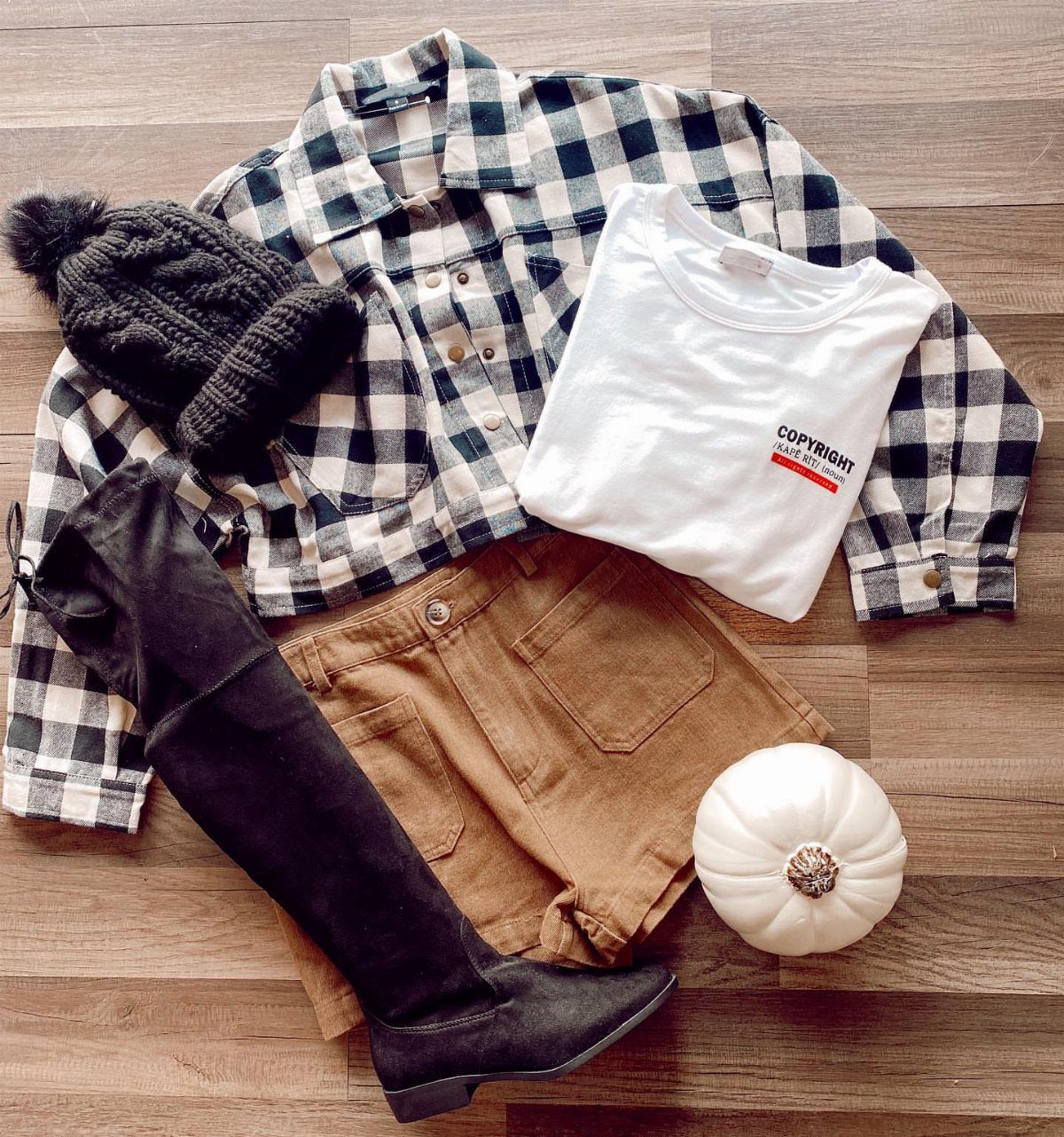 Plaid shirt and white t-shirt layered with brown shorts and black boots.
