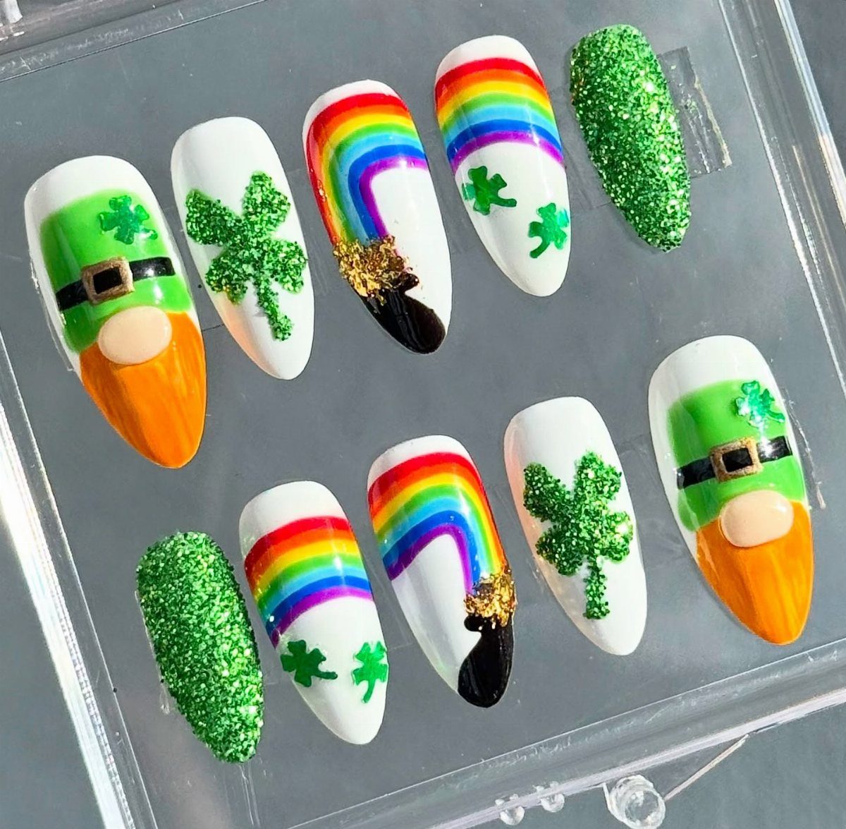 Press-on nails featuring rainbows with pots of gold, shamrocks, and leprechaun designs.