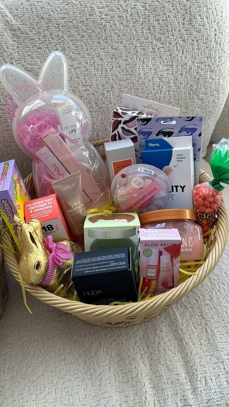 Wicker Easter basket filled with skincare, beauty products, and a gold chocolate bunny.