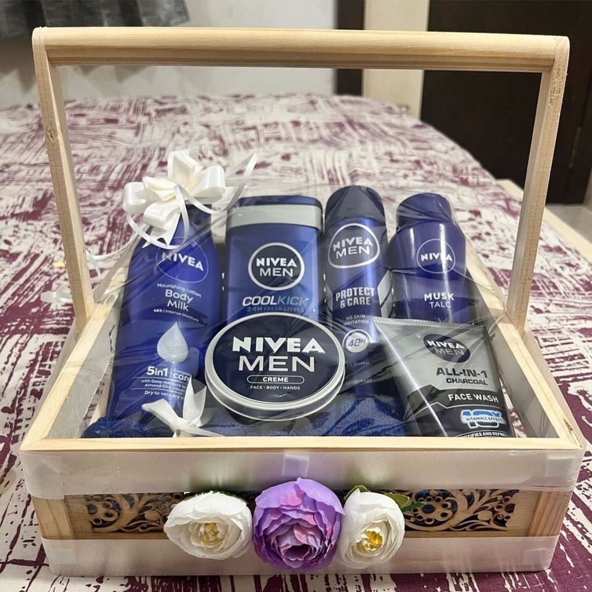 Nivea Men grooming products arranged in a wooden gift basket with decorative flowers.
