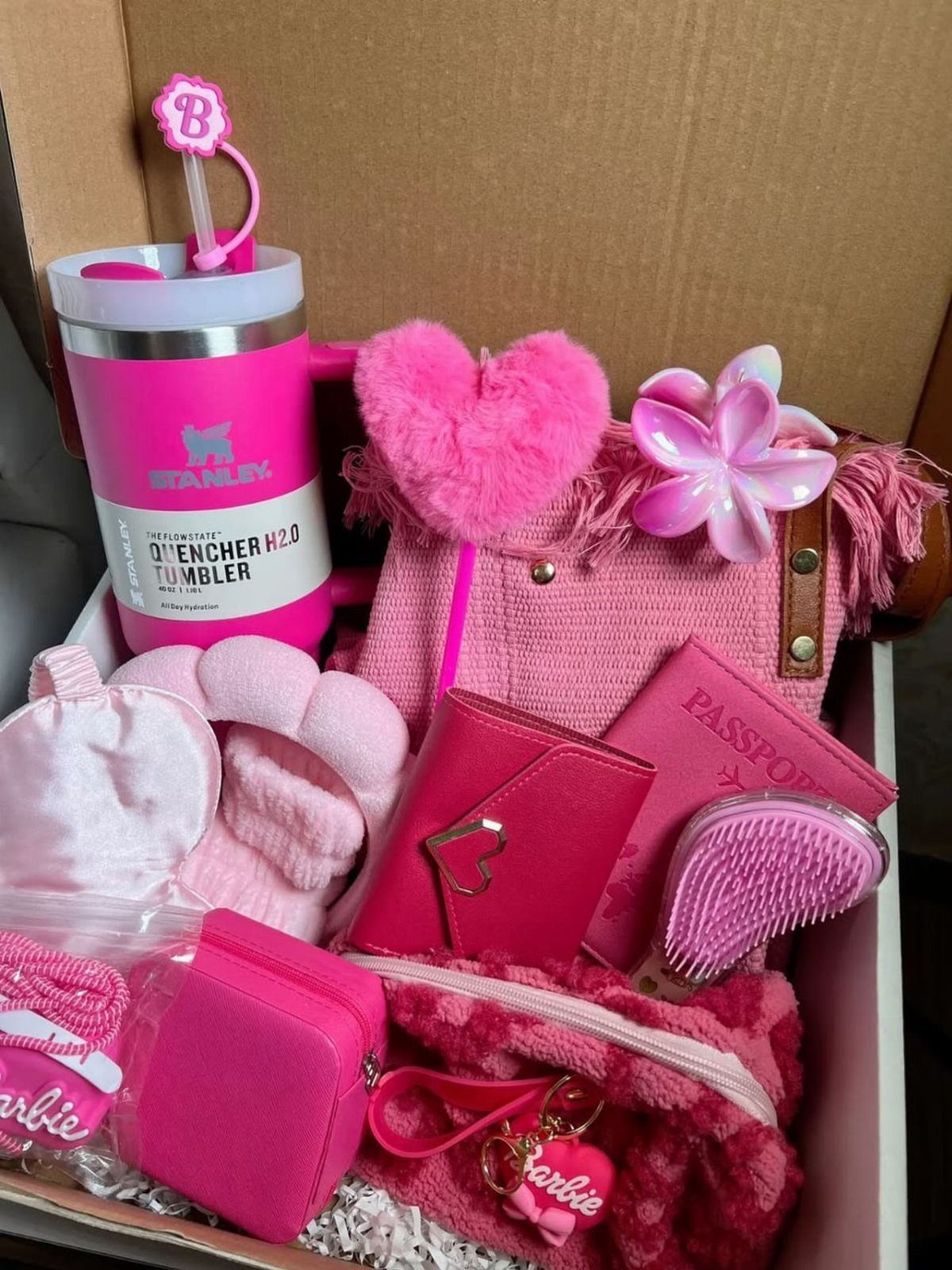 Pink gift basket containing a tumbler, handbag, and accessories in a cardboard box.