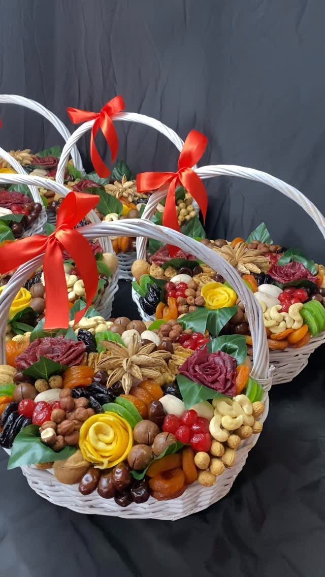 White wicker baskets filled with assorted nuts and dried fruit with red ribbons.
