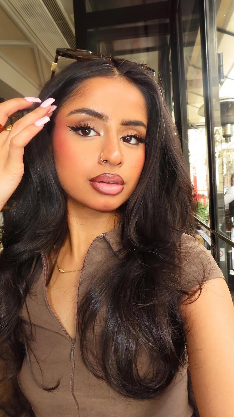 Woman with peach monochrome makeup, including eyeshadow, blush, and matching lipstick.