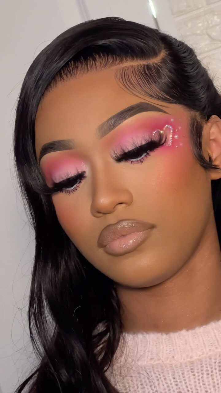 Woman with pink and red Valentine's Day makeup and rhinestones on her eyelids.