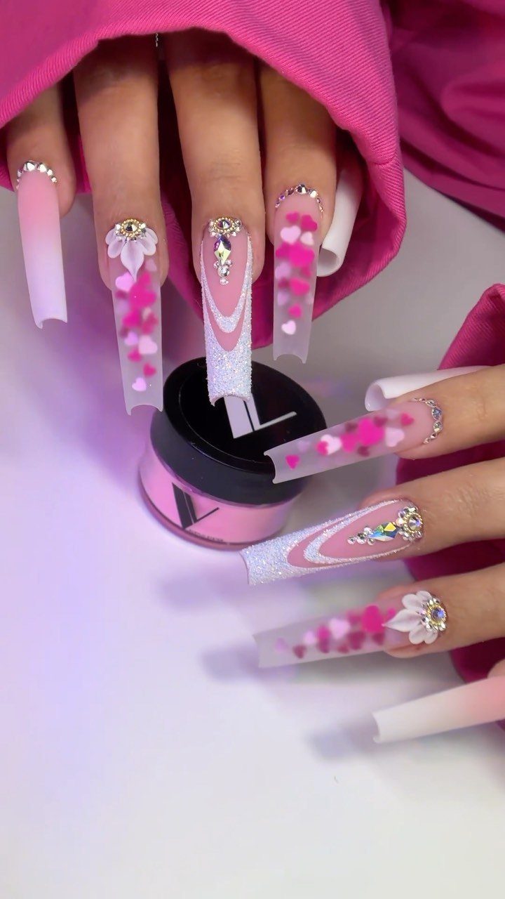 Long square acrylic nails with pink hearts and rhinestones for Valentine's Day.