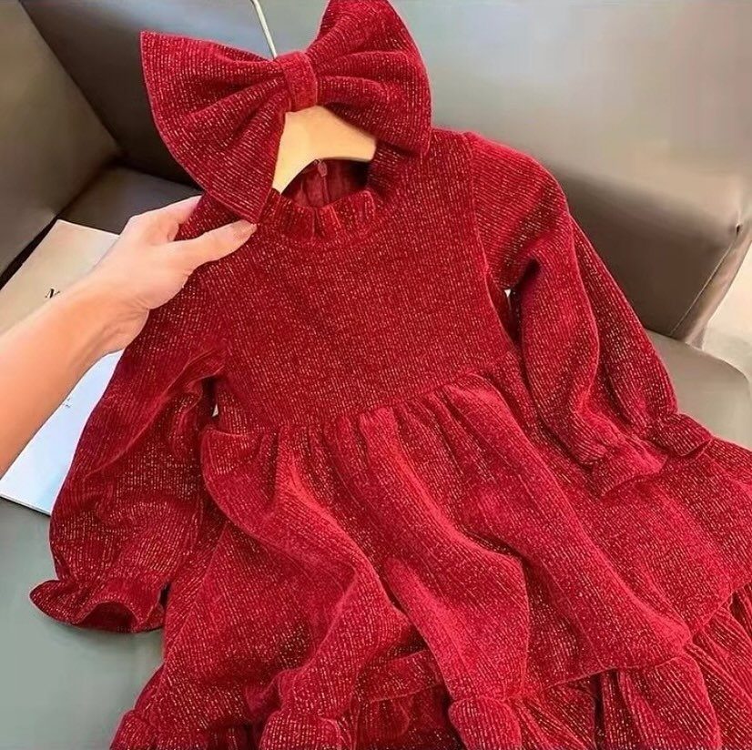 Red glittery child's dress with a matching oversized bow headband on a hanger.