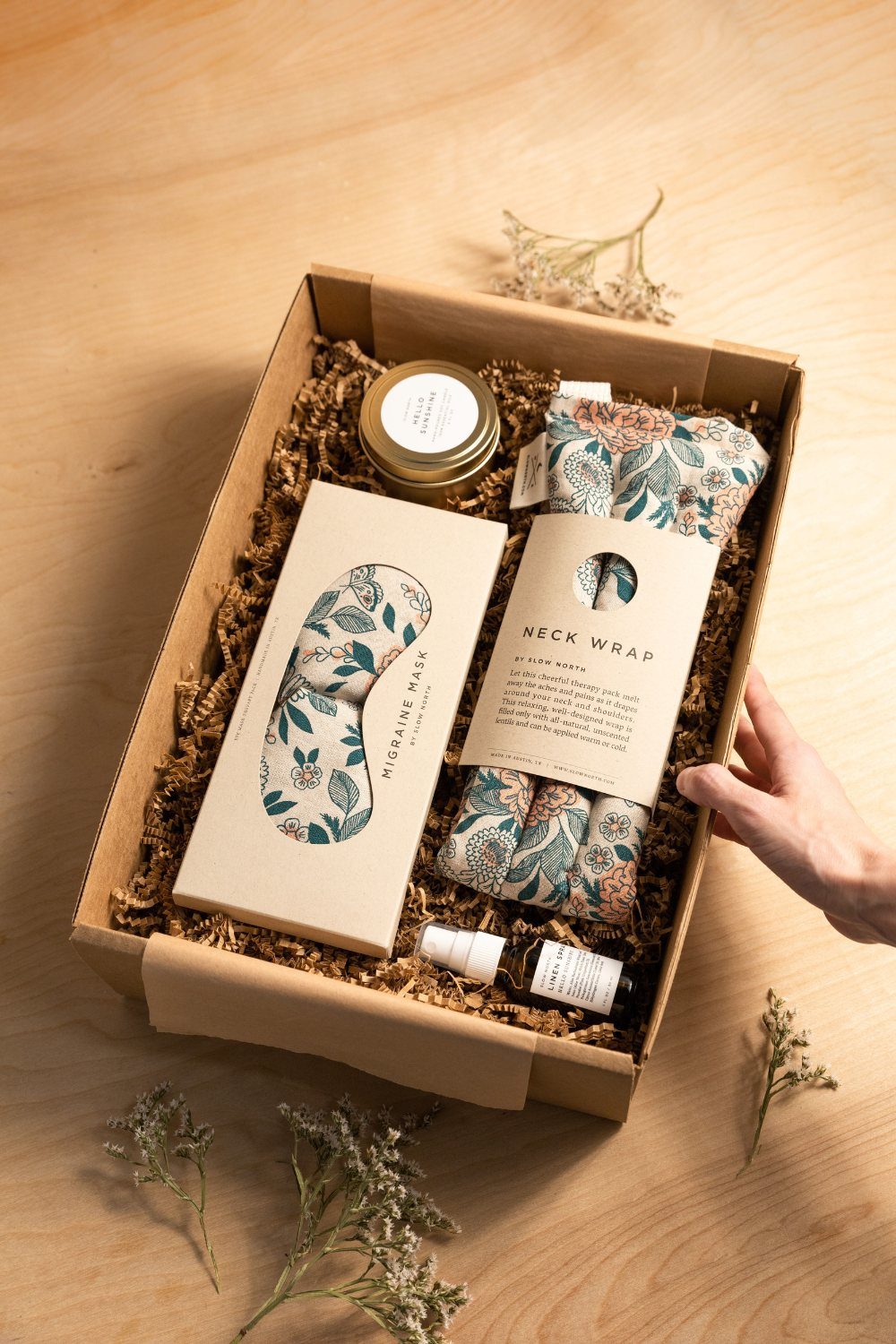 Self-care gift box with a migraine mask, neck wrap, and skincare products.